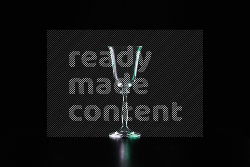 Glassware with rim light in green and white against black background