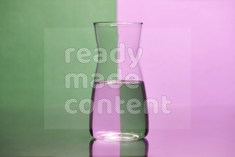 The image features a clear glassware filled with water, set against green and light purple background