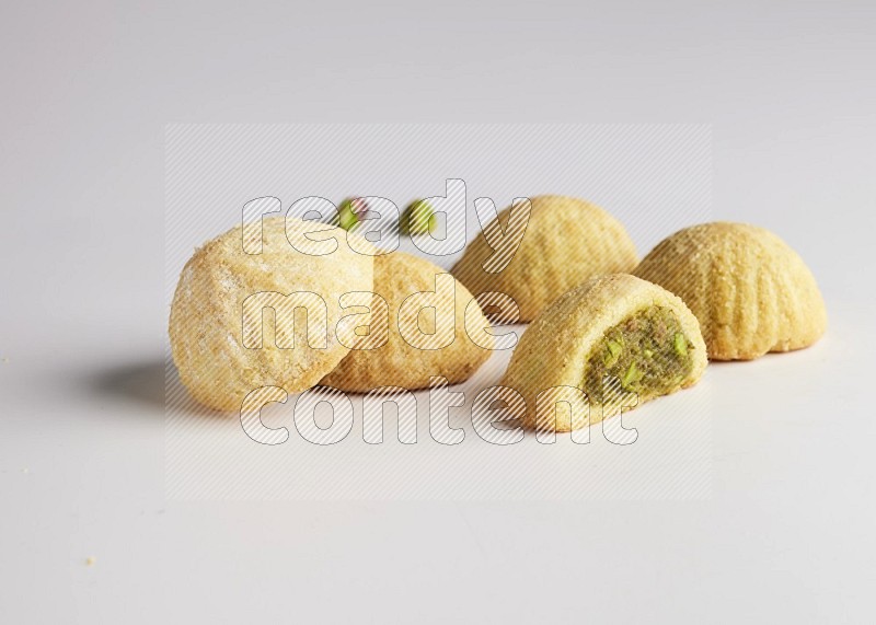 Five Pieces of Maamoul filled with pistachio  paste one of them is cut direct on white background