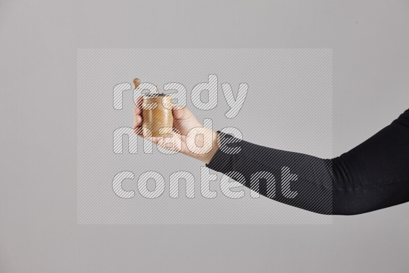 A woman in black abaya holding different wooden essentials in different positions
