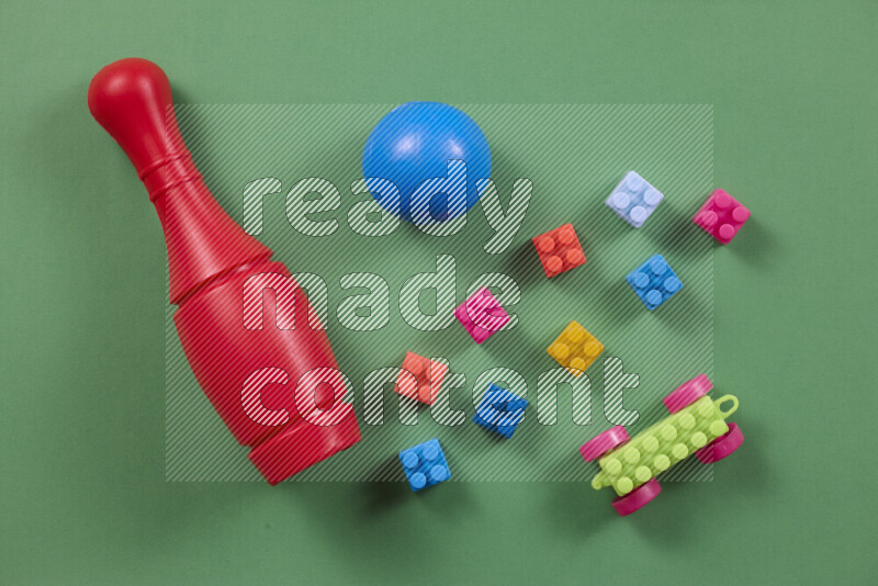 Plastic building blocks, balls and bowling pins on different colored backgrounds (kids toys)