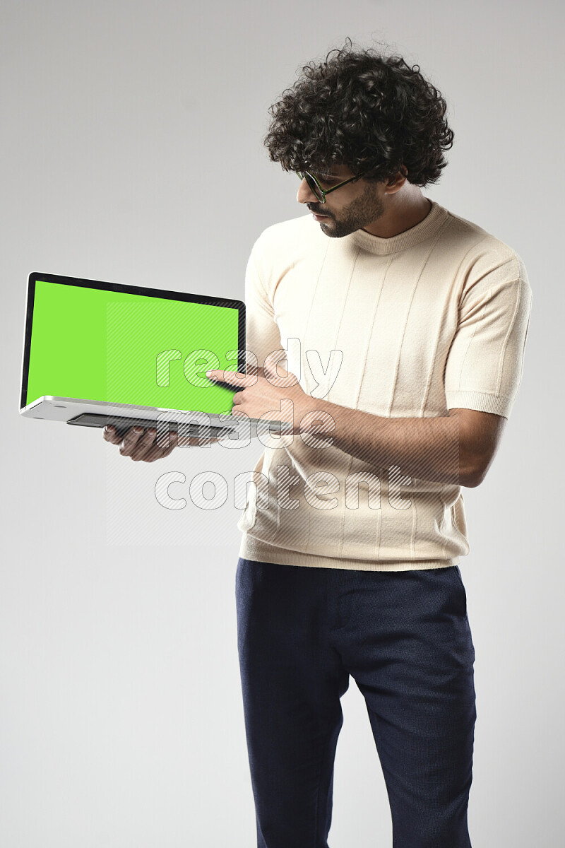 A man wearing casual standing and showing a laptop screen on white background