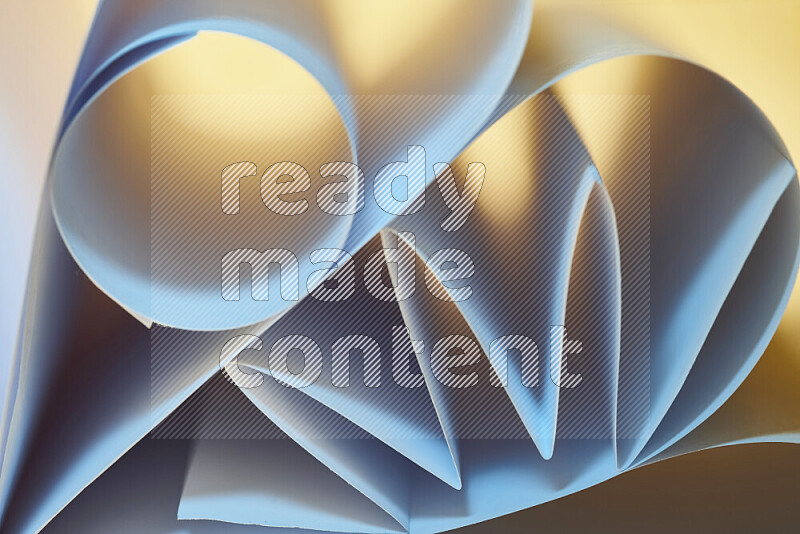 عرض فني لطيات الورق تخلق مزيج من الأشكال الهندسية، مضاءة بإضاءة ناعمة بدرجات اللون الأزرق والالوان الدافئة
