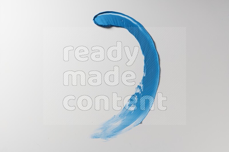 A blue single curved painting knife stroke on a white background