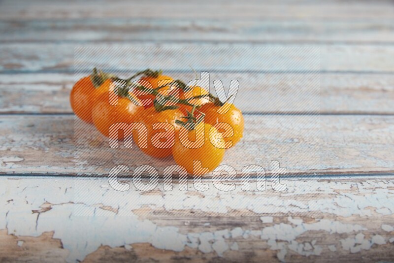 orange cherry tomato vein on a textured blue wooden background 45 degree