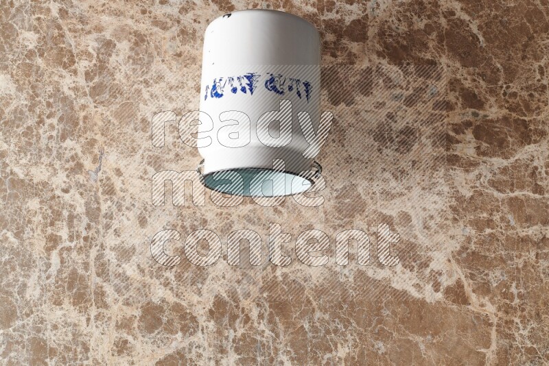 A vintage milk can on beige marble background