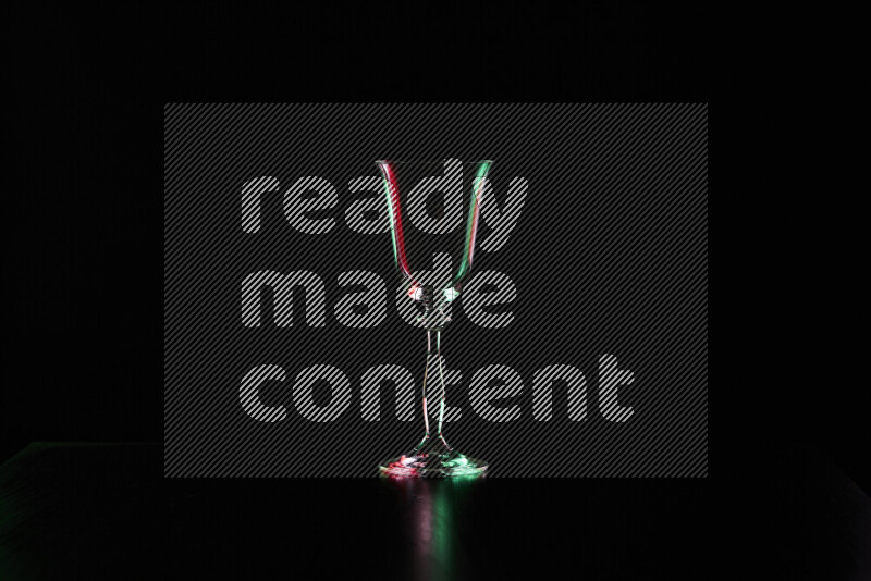 Glassware with rim light in red and green against black background