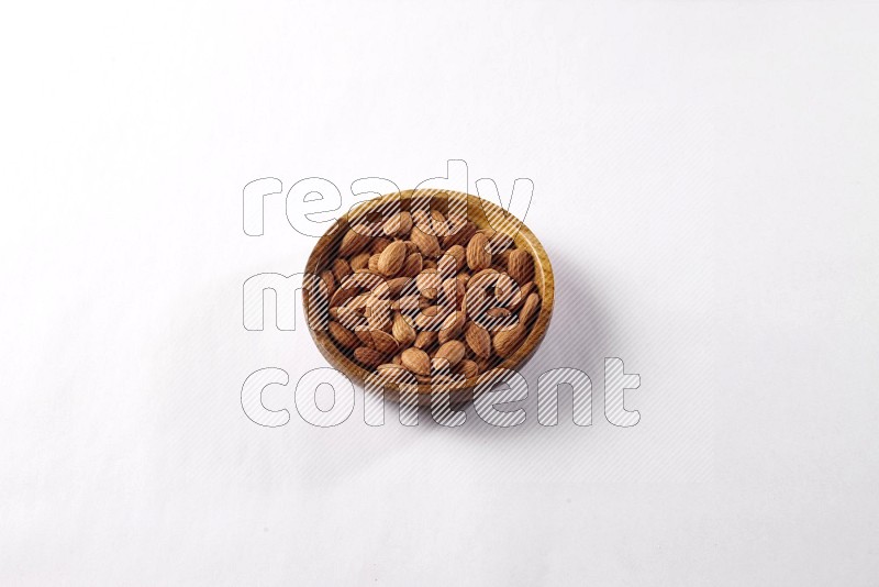 Almonds in a wooden bowl on white background