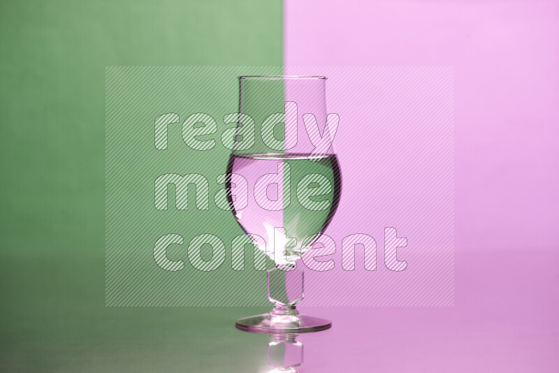 The image features a clear glassware filled with water, set against green and light purple background