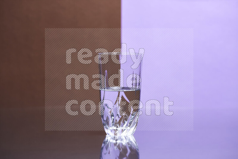 The image features a clear glassware filled with water, set against brown and light purple background
