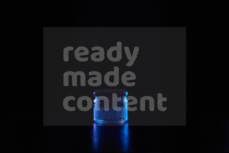 Glassware with rim light in blue against black background