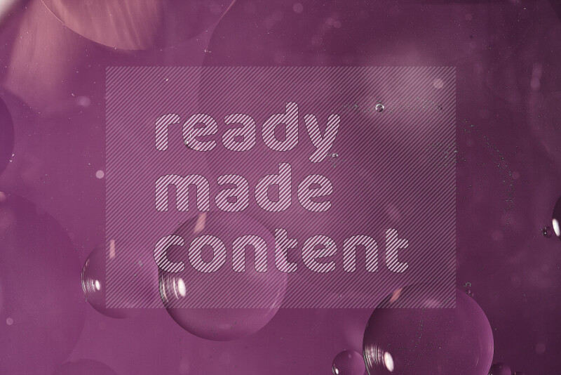 لقطات مقربة لفقاعات من الزيت على سطح الماء باللون الأرجواني