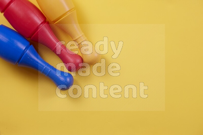 Multicolored plastic bowling pins on different colored backgrounds background (kids toys)