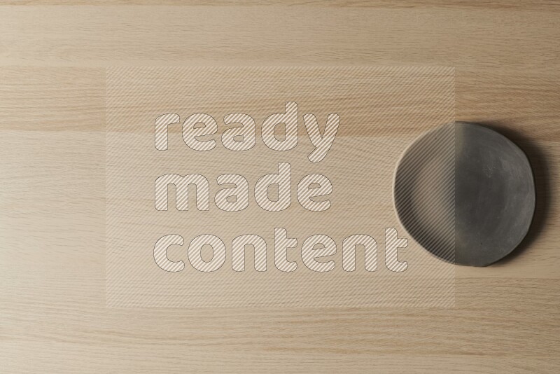 A multicolored pottery plate on light wooden background