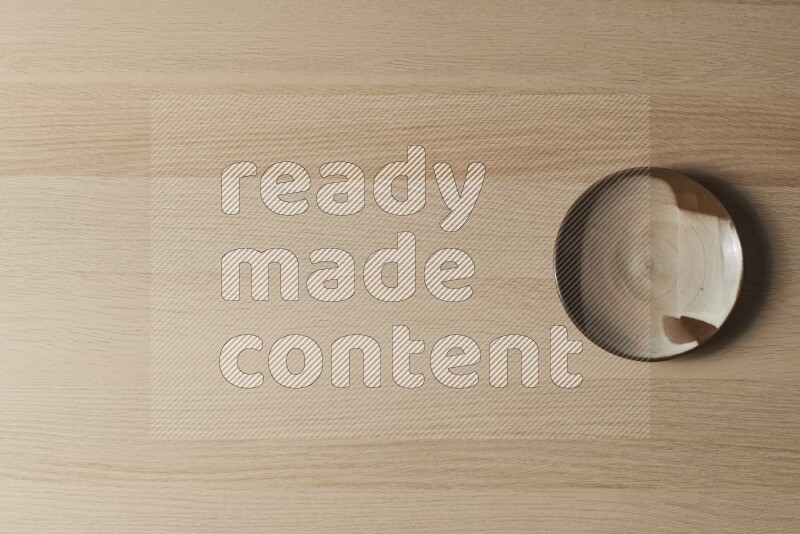 A multicolored pottery plate on light wooden background