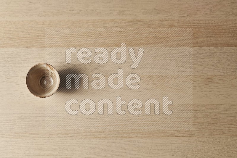 Top View Shot Of A Beige Pottery Bowl on Oak Wooden Flooring
