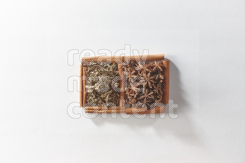 2 squares of cinnamon sticks full of star anise and dried basil on white flooring