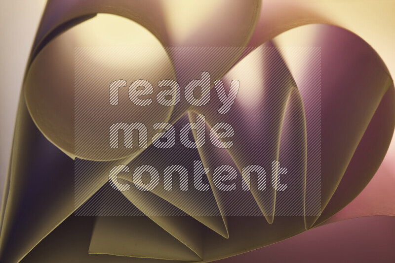 An artistic display of paper folds creating a harmonious blend of geometric shapes, highlighted by soft lighting in pink and warm tones