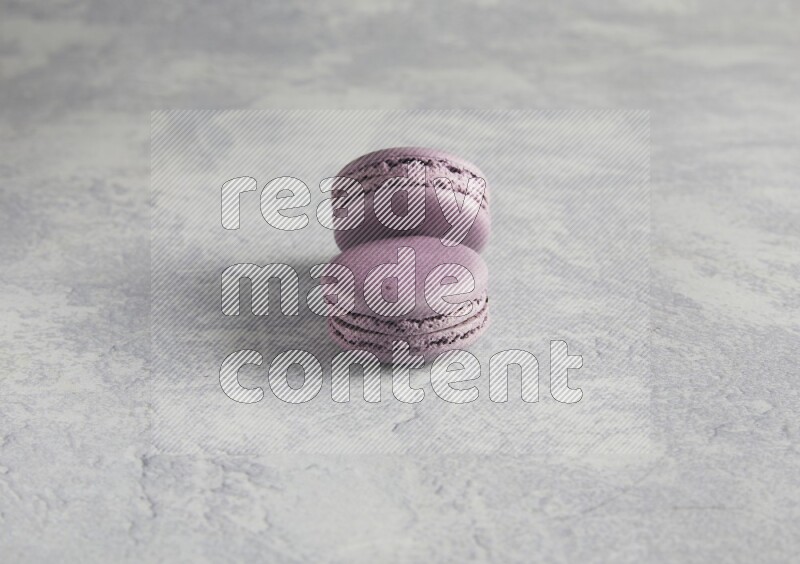 45º Shot of two Purple Blueberry macarons  on white  marble background