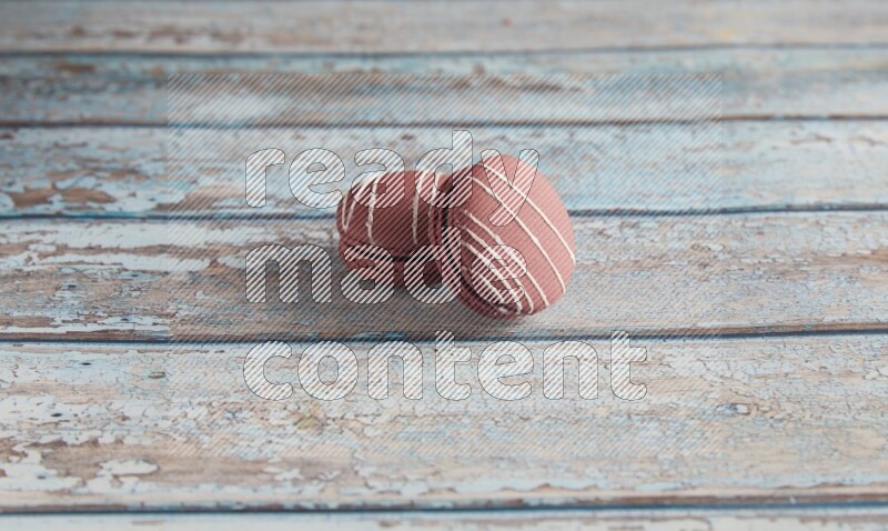45º Shot of two Red Poppy Flower macarons on light blue wooden background
