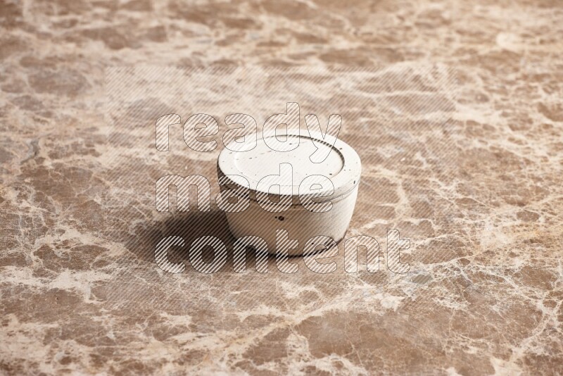 A white pottery bowl on beige marble background