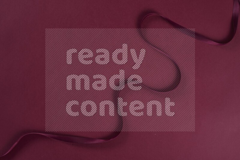 A red collection of sewing and tailoring tools arranged on a red background