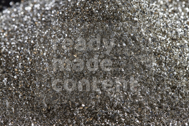 قطع زجاجية فضية لامعة متناثرة على خلفية سوداء