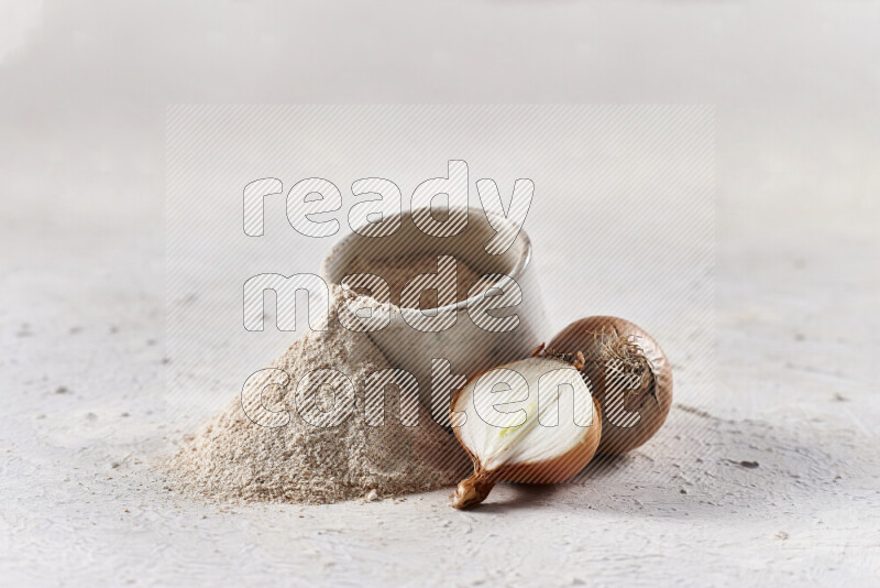 A beige pottery bowl full of onion powder with fallen powder from it on white background