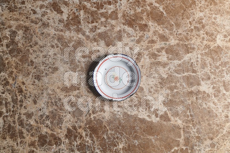 Top View Shot Of A Vintage Metal Plate On beige Marble Flooring