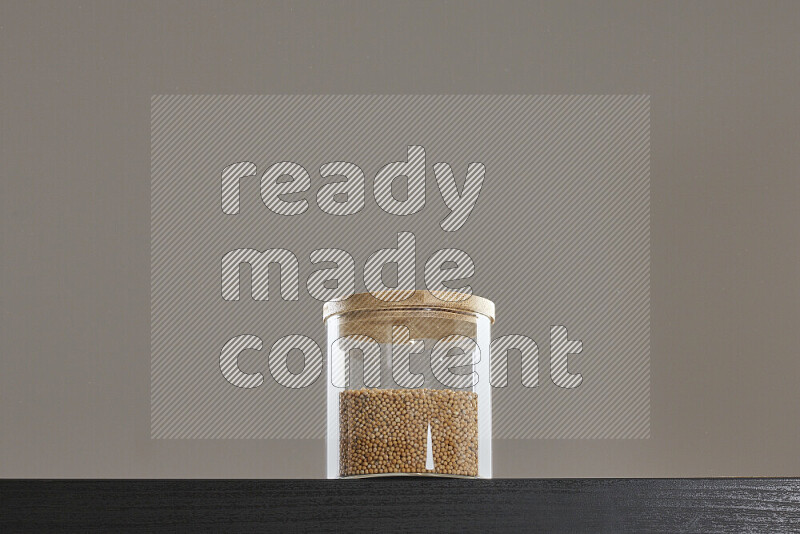 Mustard seeds in a glass jar on black background