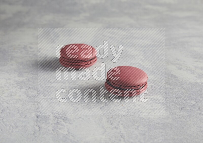 45º Shot of two Red Cherry macarons  on white  marble background