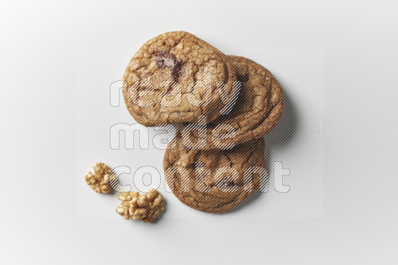 Chocolate chips cookies with walnuts beside it on a white background