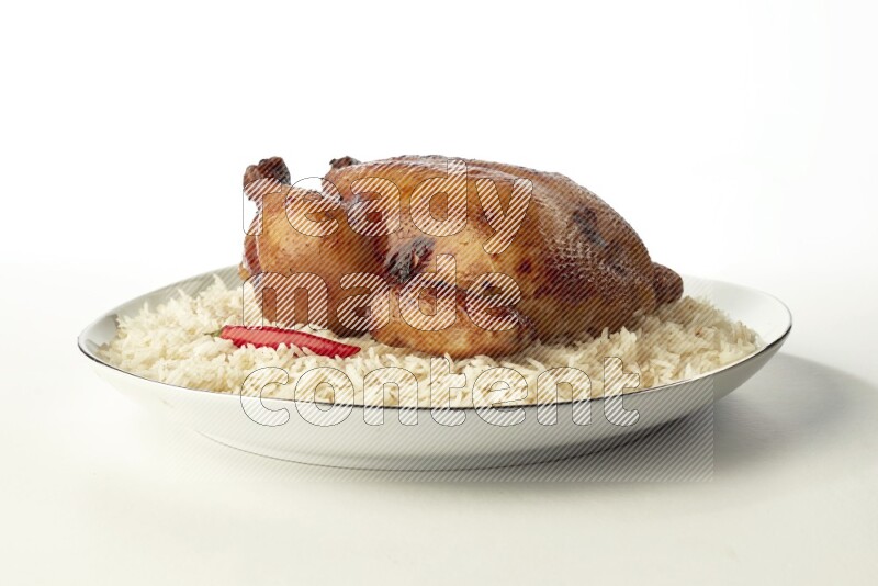 white  basmati Rice with  whole roasted chicken  on a white plate with a silver rim direct  on white background