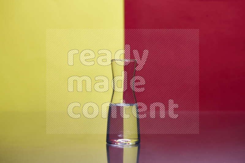 The image features a clear glassware filled with water, set against yellow and red background