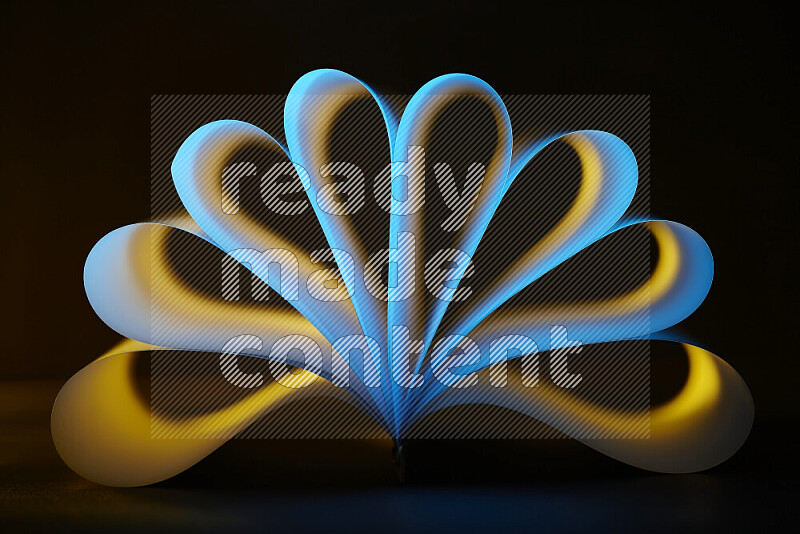 An abstract art piece displaying smooth curves in yellow and blue gradients created by colored light