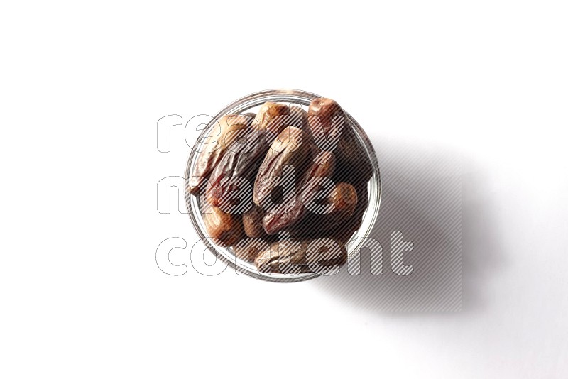 Dates in a glass bowl on white background