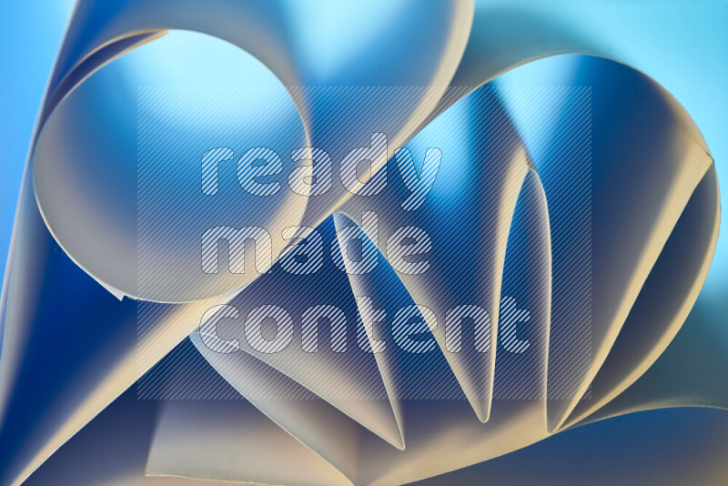 عرض فني لطيات الورق تخلق مزيج من الأشكال الهندسية، مضاءة بإضاءة ناعمة بدرجات اللون الأزرق والالوان الدافئة