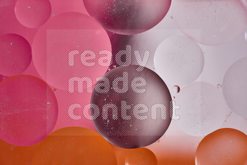 لقطات مقربة لفقاعات من الزيت على سطح الماء باللون الأبيض والبرتقالي والوردي