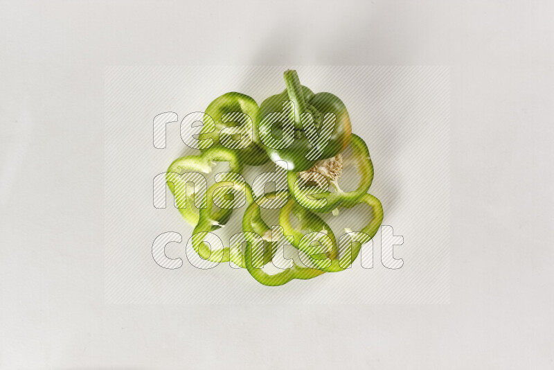 Green bell pepper slices on white background