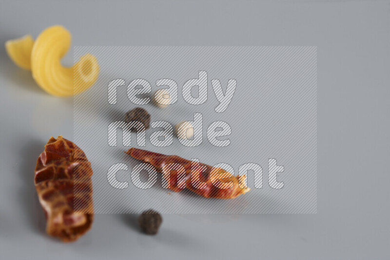 معكرونة مع مكونات متنوعة من الطماطم والثوم والبصل والفلفل الأحمر والفلفل الأسود والفلفل الأبيض وأوراق الغار وإكليل الجبل والهيل و مشروم على خلفية زرقاء فاتحة