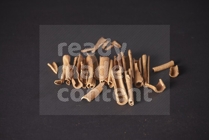 Cracked cinnamon sticks on a black background