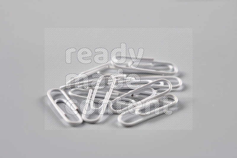 White paper clips isolated on a grey background