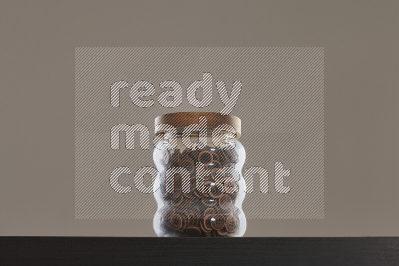 Buttons in a glass jar on black background