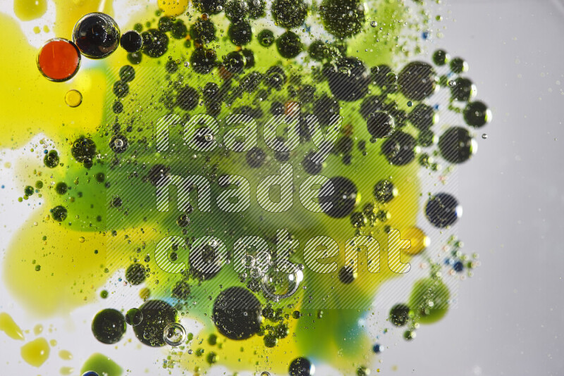 Close-ups of abstract red, blue, yellow and green watercolor drops on oil Surface on white background