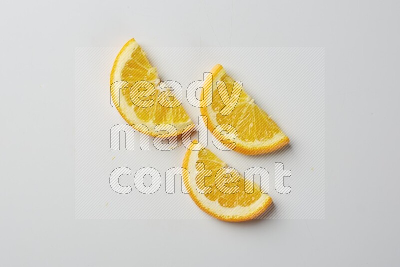 Three halves of an orange slices on white background