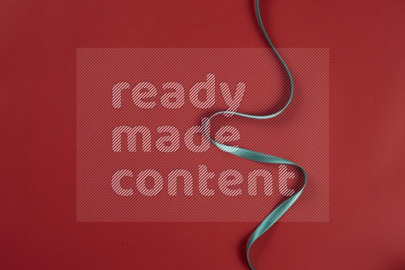 A green and red collection of sewing and tailoring tools arranged on a red background