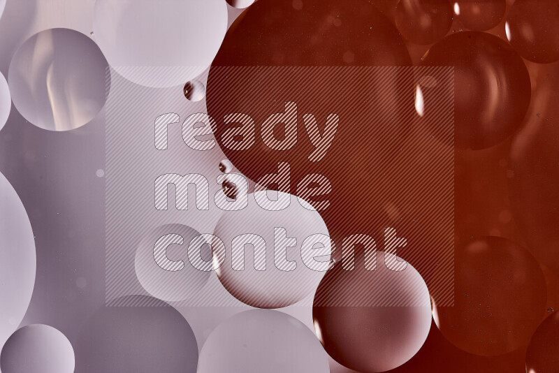 لقطات مقربة لفقاعات من الزيت على سطح الماء باللون الأبيض والبرتقالي