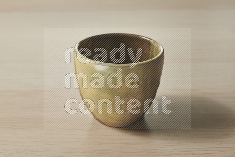 A multicolored pottery bowl on light wooden background