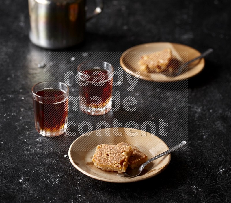 Basbousa with tea in a dark setup