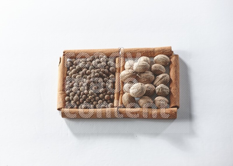 2 squares of cinnamon sticks full of allspice and nutmegs on white flooring